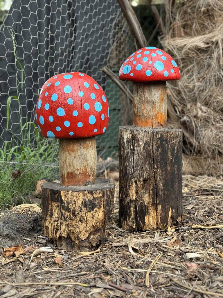 Wooden mushrooms, brightly painted red with blue dots